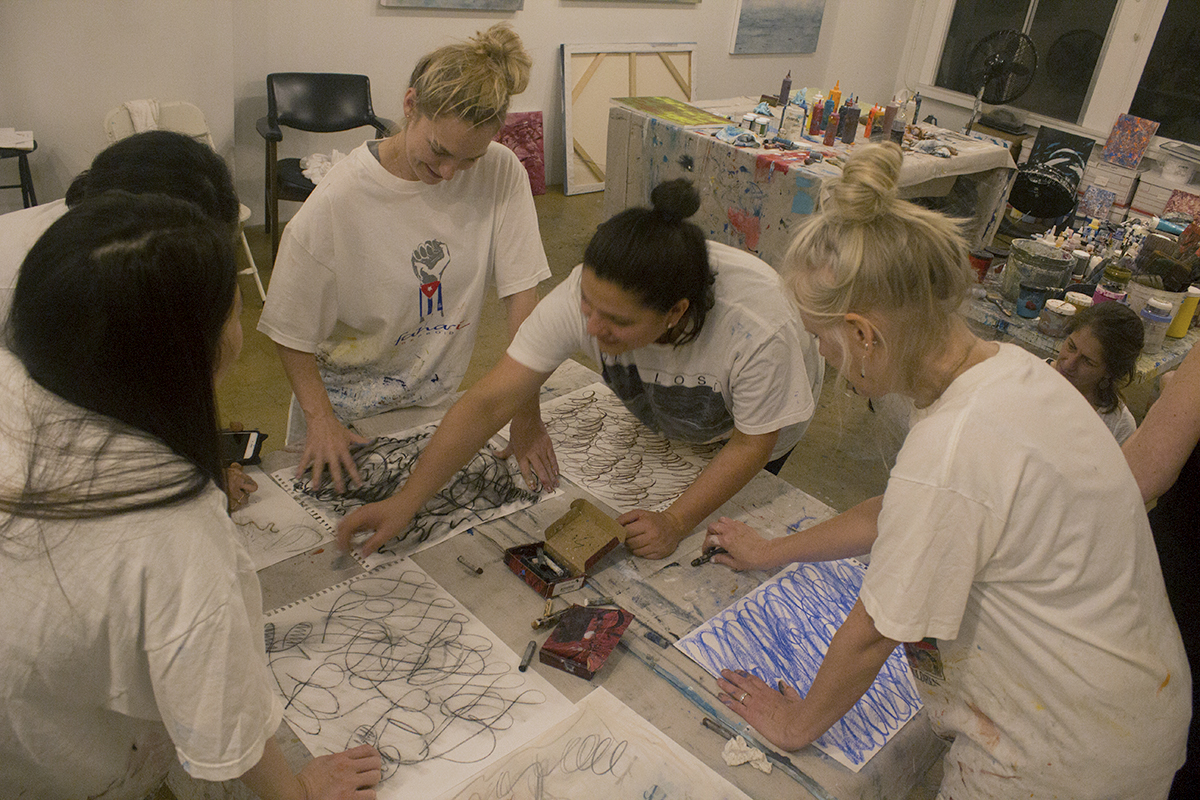 Students play with chalk during Clara Berta's Ladies Night In art class