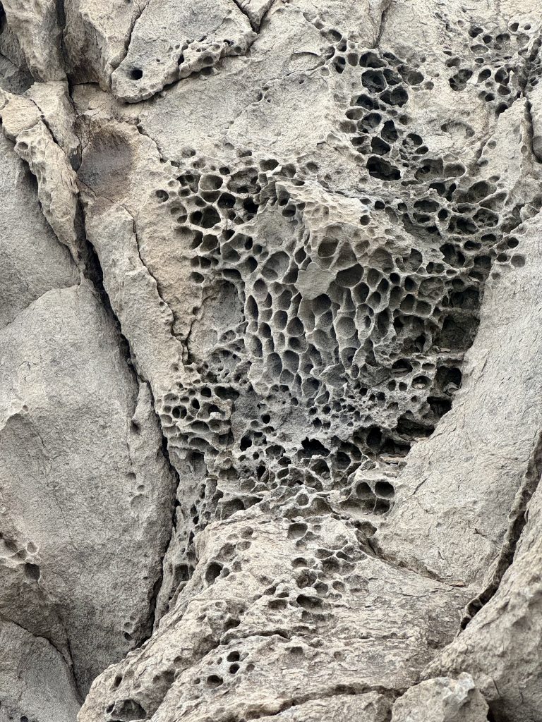 Close-up of rugged, porous volcanic rock and weathered terrain along the Pe’ahi (Jaws) hiking trail in Maui, showing the 