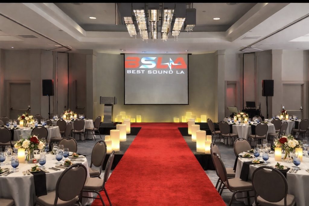 Oscar's gala ballroom is decorated with large flameless wax candle art along red carpet aisle, luxury wax candle rental for corporate events and galas