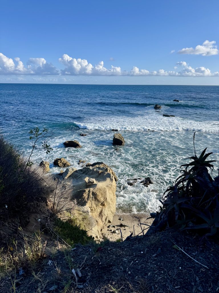 Coastal photography of Heisler Park in Laguna Beach by Clara Berta. A scenic view of rocky tide pools, turquoise Pacific Ocean waves, and the California coastline under bright, natural light.