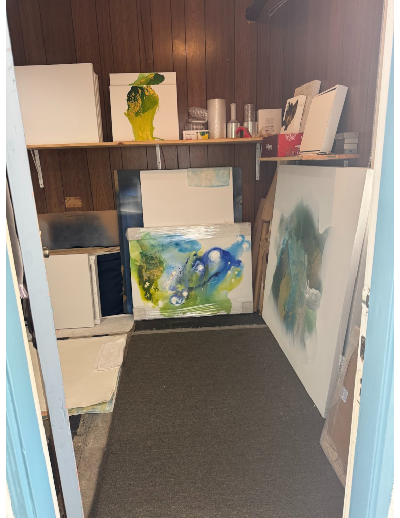 Inside Clara Berta’s Laguna Beach artist studio. The space is filled with great natural lighting that illuminates several abstract paintings on the walls and easels. The atmosphere is bright and creative, showcasing works from the Ethereal Series.