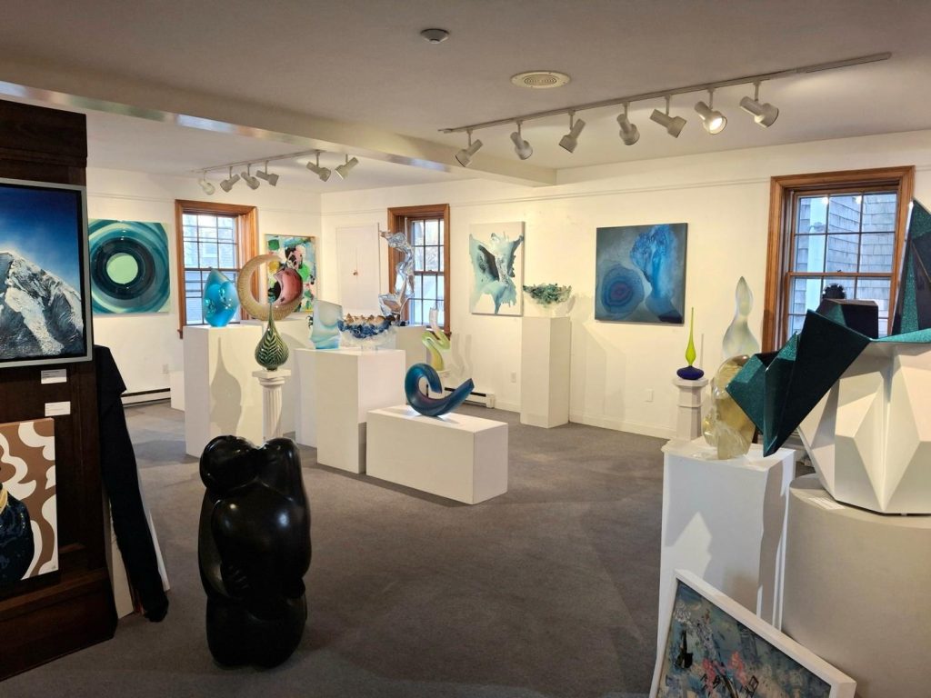 Gallery installation view of Clara Berta's abstract mixed media paintings hanging on the walls at the Art4India exhibition.