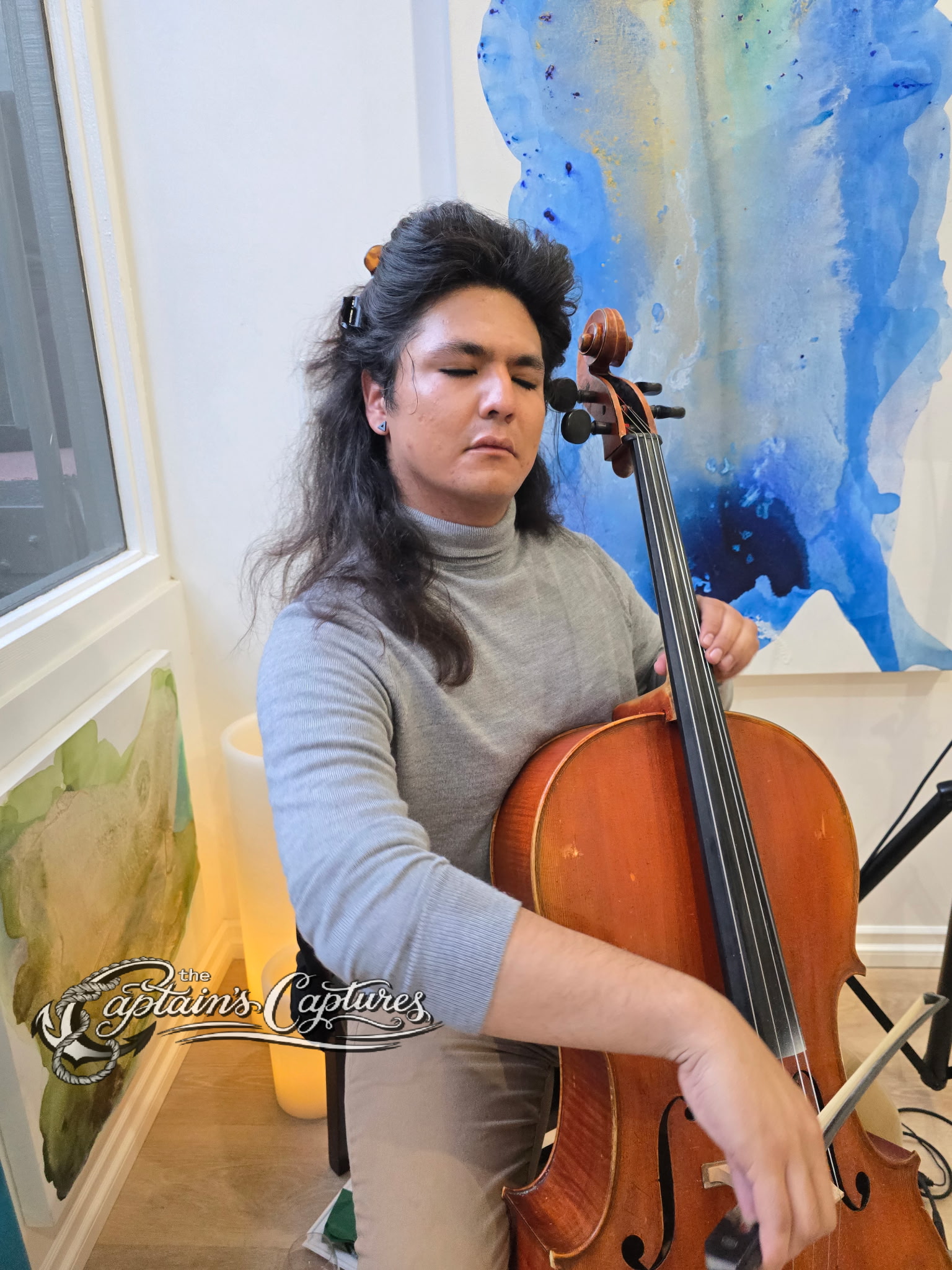 Cellist Alex Sanchez playing at the grand opening art exhibition of Clara Berta Studio, Laguna Beach