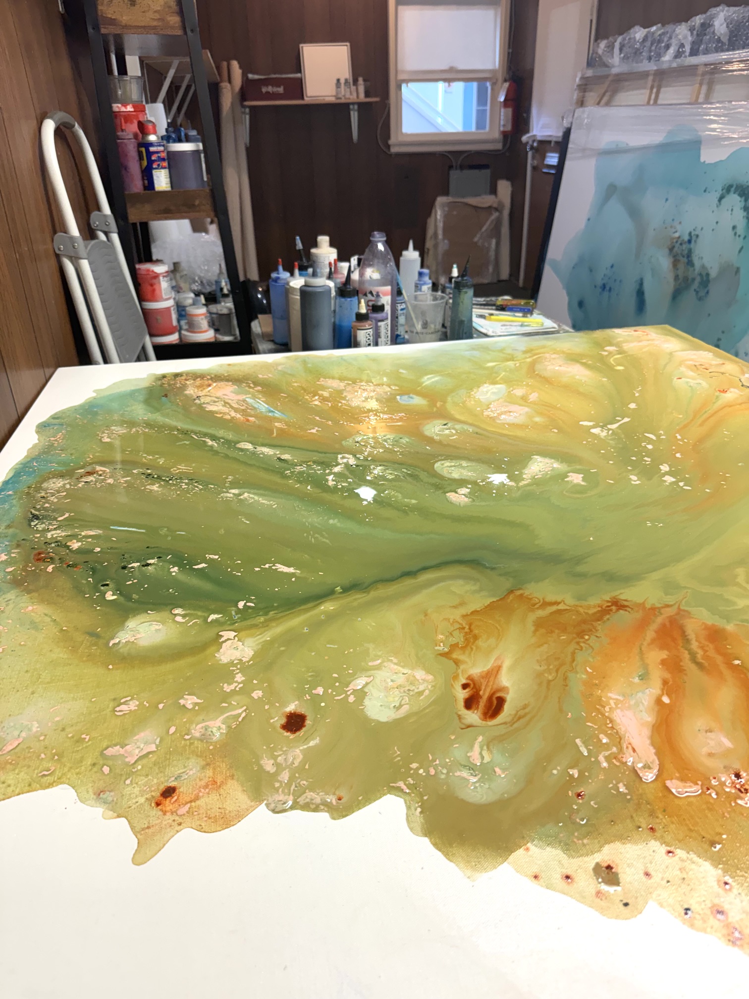 Close-up detail of the thick acrylic textures and fluid paint layers on a table, showing the physical beauty of finding my creative flow.