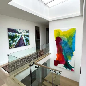 Large 60x120 "Calgary, My Love" artwork hanging in a stylish staircase setting with warm lighting highlighting its details.
