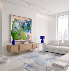 Large framed abstract fluid painting by Clara Berta titled 'Crystal Cove,' featuring blue, green, and white organic patterns, displayed in a modern, all-white condo living room above a light wood credenza.
