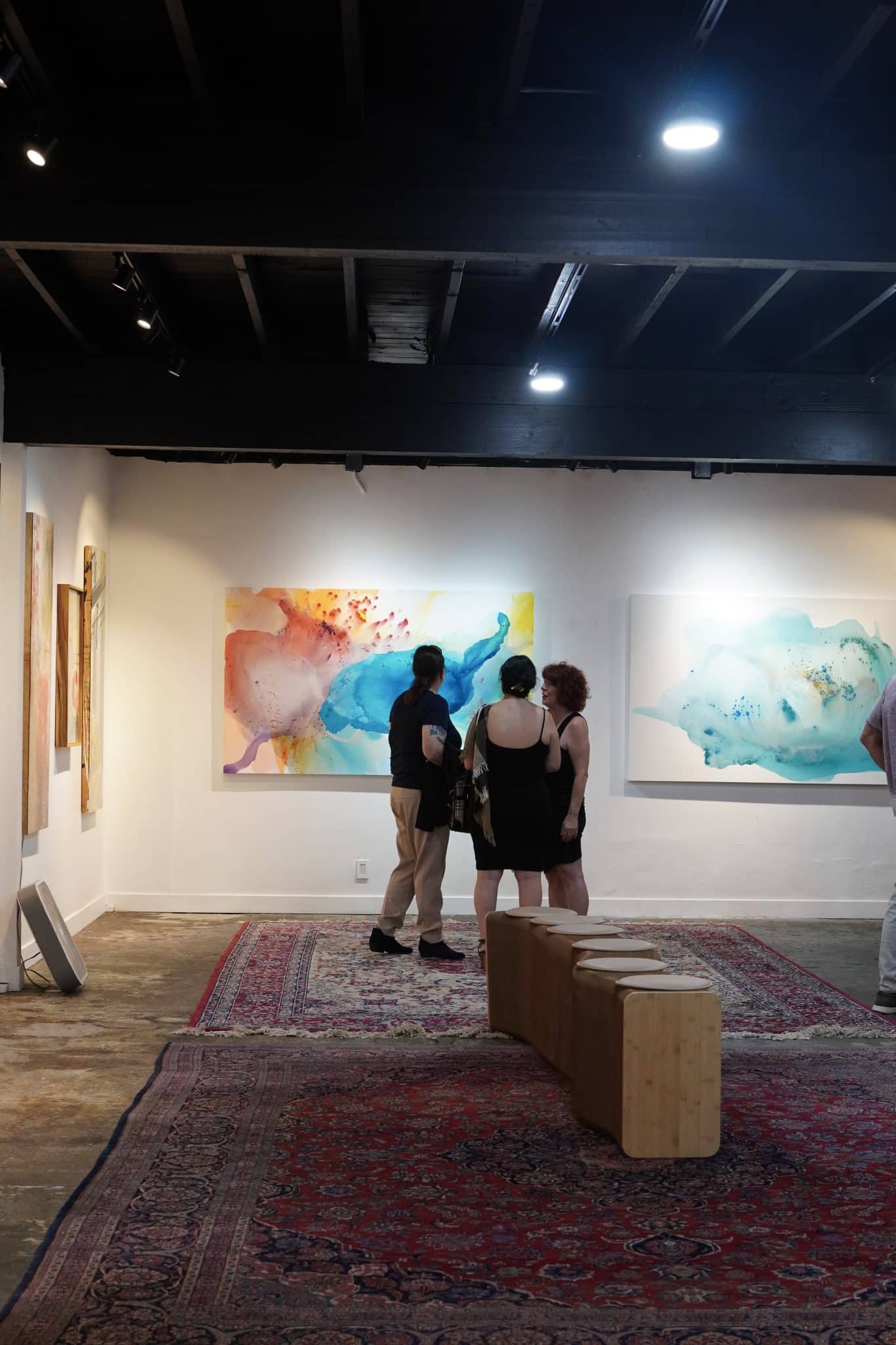 Guests viewing modern abstract artworks Expansive Light and Dreamy Light by Clara Berta.
