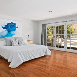 'Falling Leaf' painting by Clara Berta, installed in a collector's bedroom. Minimalist blue flowing abstract painting by artist Clara Berta installed into an art collector's modern interior bedroom