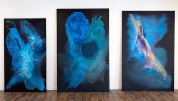 ClaraBerta-large scale works Clara Berta large-scale abstract blue triptych with three fluid panels on a dark background.